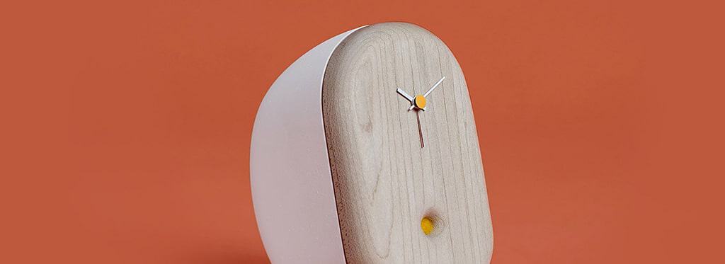 Minimalistische houten klok met witte rand op oranje achtergrond.