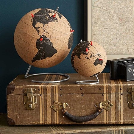 Twee wereldbollen op een vintage koffer met kaart en radio.
