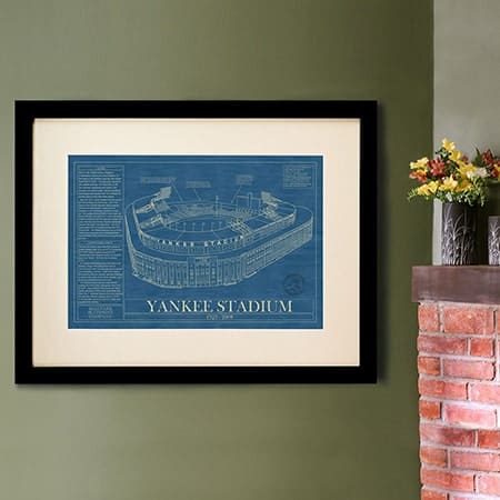 Blueprint van Yankee Stadium in een zwart lijstje aan een groene muur.