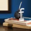 Facebook logo op een bommetje op boeken, symboliseert social media en communicatie.