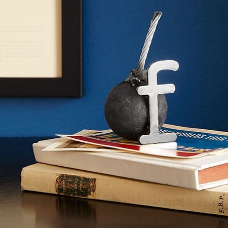 Facebook logo op een bommetje op boeken, symboliseert social media en communicatie.
