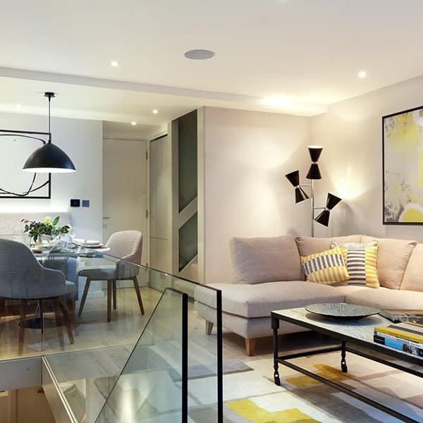 Lichte en moderne woonkamer met zithoek en decoratieve elementen.