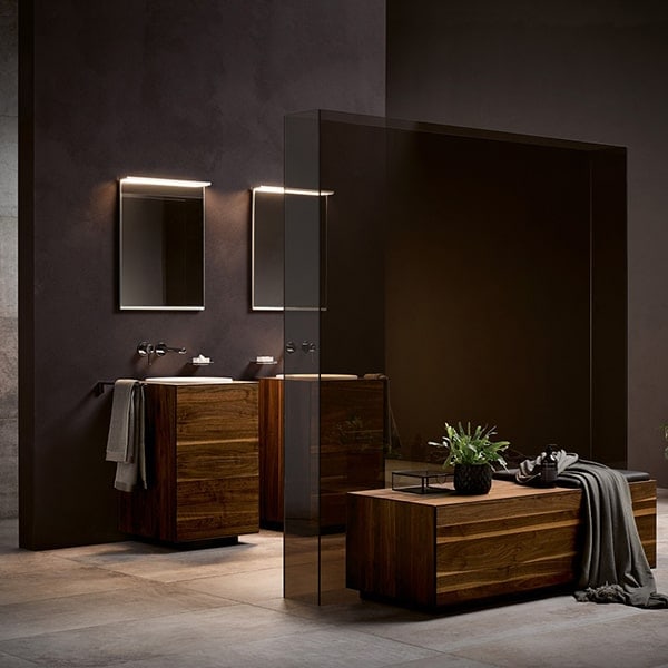 Stijlvolle badkamer met houten wastafels, spiegels en zachte verlichting.