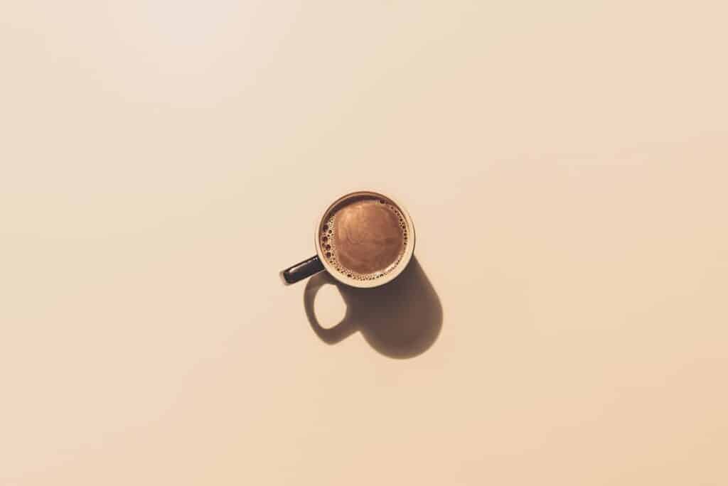 Kop koffie op een witte achtergrond, minimalistisch en rustgevend.
