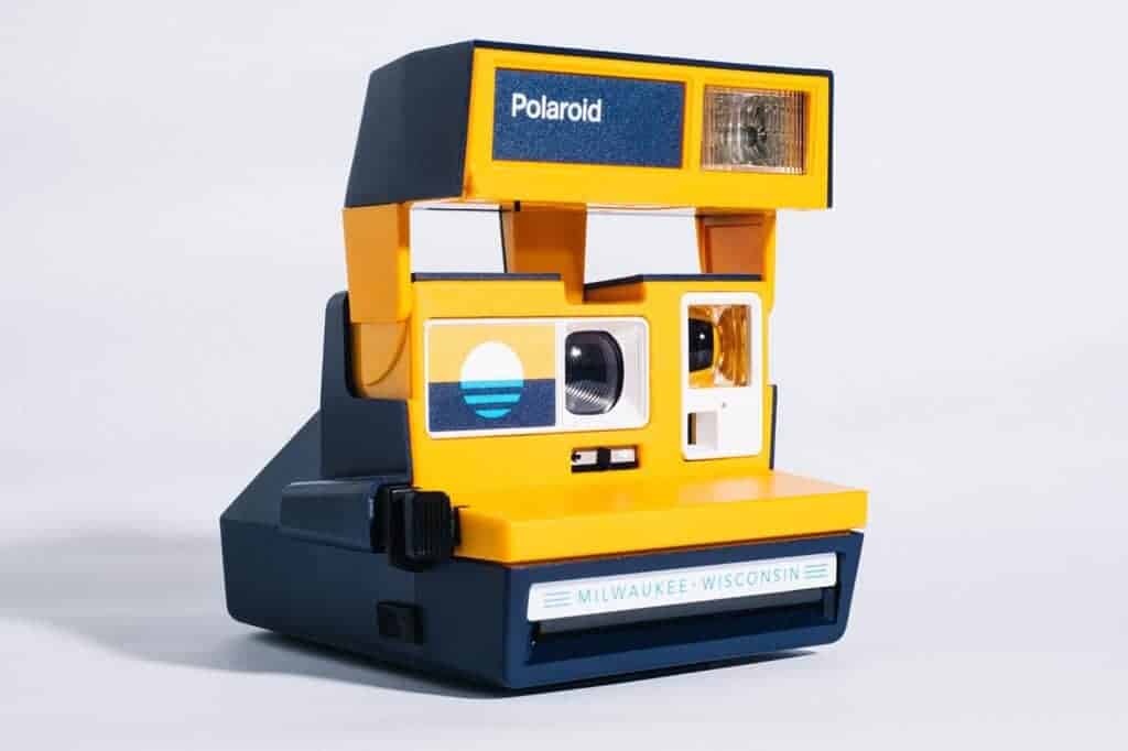 Vintage Polaroid camera in geel en blauw met merknaam.