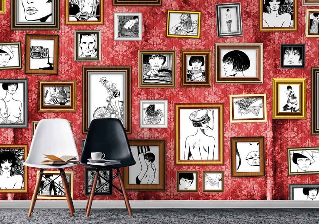 Kunstgalerij met diverse zwart-wit tekeningen en fotolijsten op rode muur.