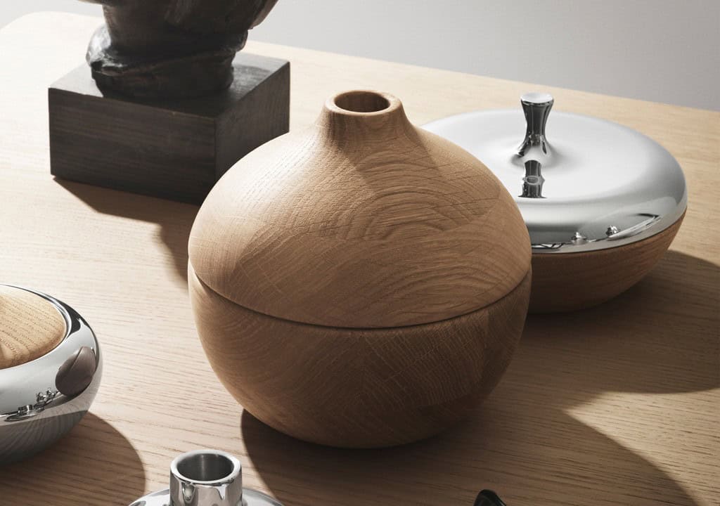 Decoratieve houten en metalen vazen en objecten op een houten tafel.