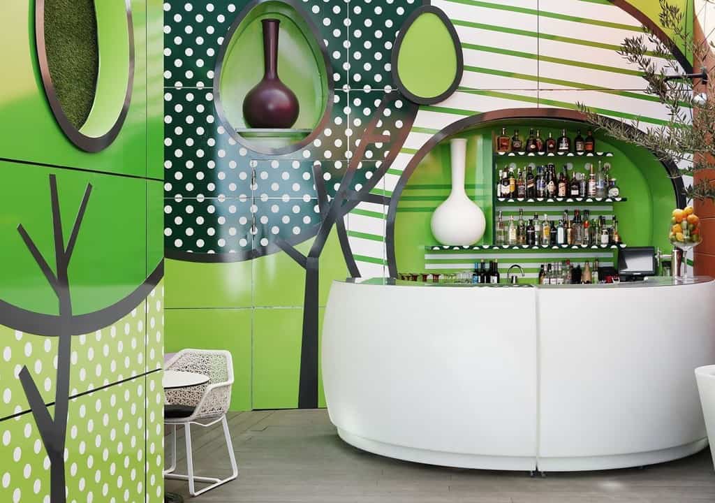 Modern wellness centrum met groene muur en bar met diverse drankjes.