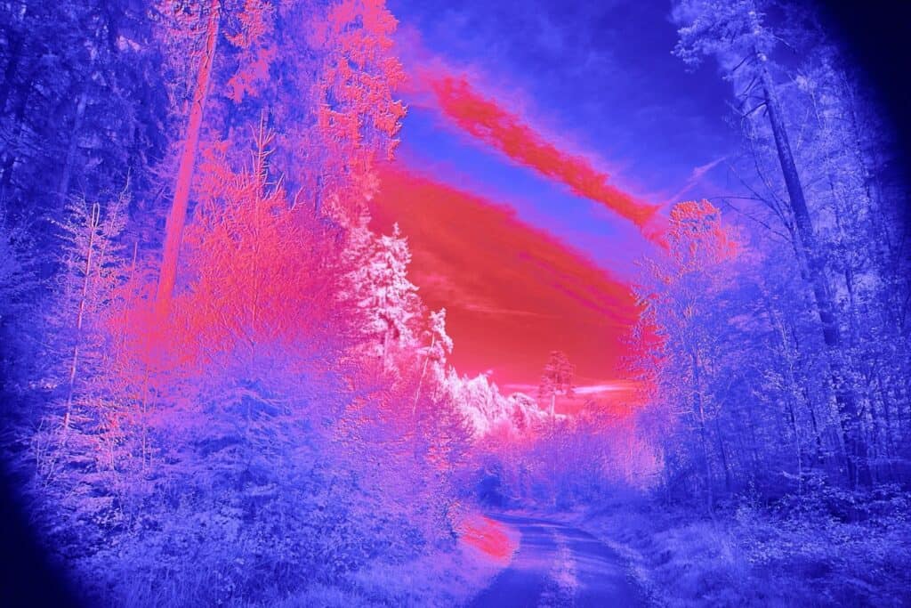 Infrarood landschap met kleurrijke zonsondergang en bos, ideaal voor infraroodfotografie en wellness.